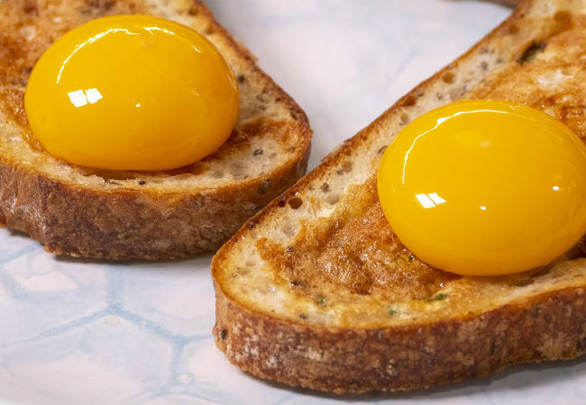 Яичница готова вместе с хлебом: разбиваем желток внутрь и жарим вместе
