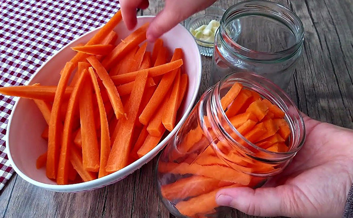 Режем морковь вдоль и кладем в банку с маслом и чесноком. Закуска на замену соленым огурцам