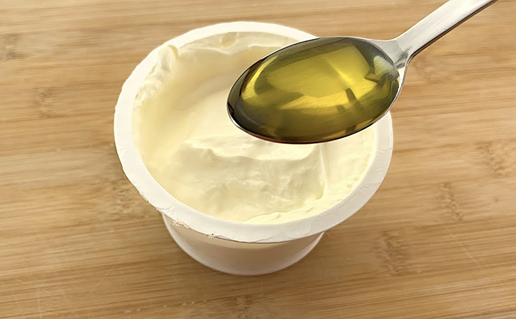 Отжимаем лишнюю влагу из йогурта и добавляем 2 ложки масла. После остывания сливочный сыр готов