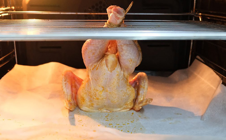 Ставим курицу в духовку, но готовим вертикально. Вниз положили картошку и она пропитывается соком